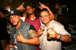 Three Latinos posing in a bar.